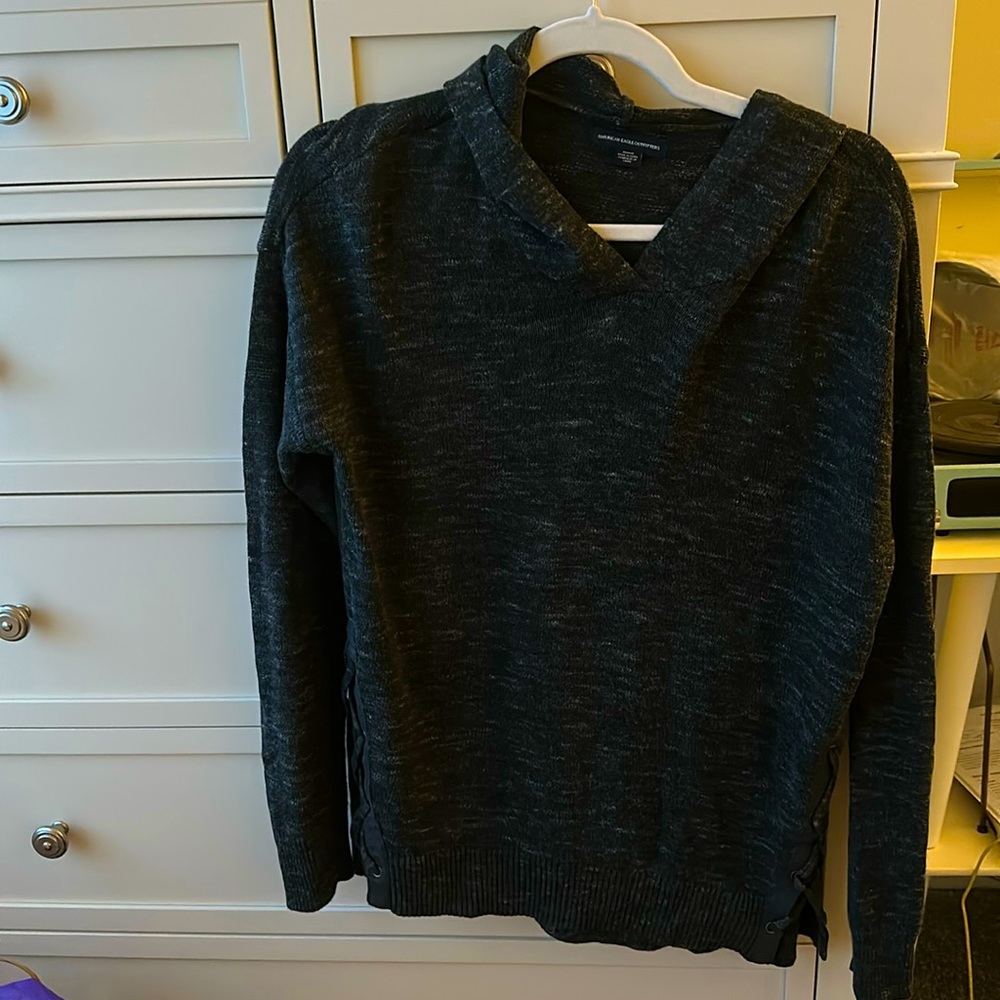 Grey sweatshirt with hoodie and ties on both sides.